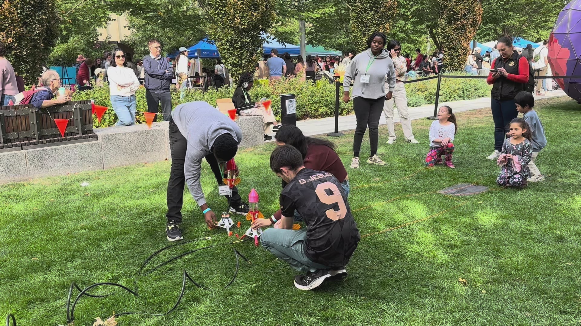 Load video: Three water rockets launching from a grassy lawn